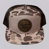 Camouflage trucker hat with 'Freedom Union' logo on a light gray background