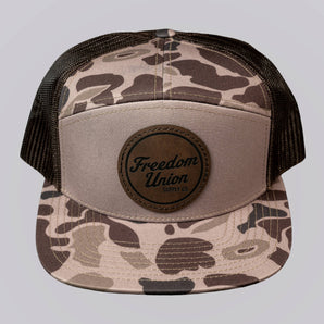 Camouflage trucker hat with 'Freedom Union' logo on a light gray background