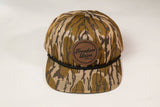 Camouflage-patterned cap with a brown leather patch on a white background
