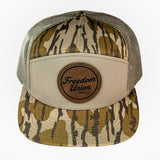 Camouflage trucker hat with a brown leather patch on a white background