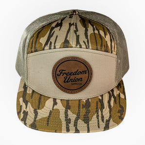 Camouflage trucker hat with a brown leather patch on a white background