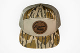 Camouflage trucker hat with a brown leather patch on a white background