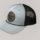 Gray and black cap with leather patch on a beige background