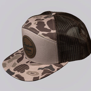 Camouflage-patterned cap with black mesh back on a light gray background