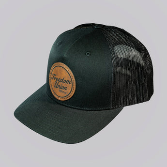 Green cap with a leather patch on a light gray background