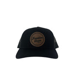 Black suede snapback hat with brown circular Freedom Union logo patch